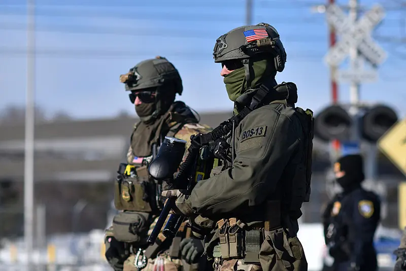 Federal law enforcement agents confront anti-US Immigration and Customs Enforcement (ICE) protesters outside the Bishop Henry Whipple Federal Building during a demonstration over the fatal shooting of Renee Good by an ICE agent in Minneapolis, Minnesota, on January 9, 2026. (Photo by Octavio JONES / AFP via Getty Images)